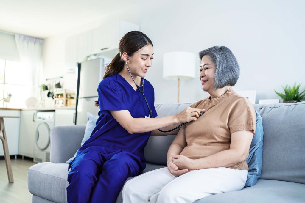 A nurse is checking the blood pressure of an older woman.