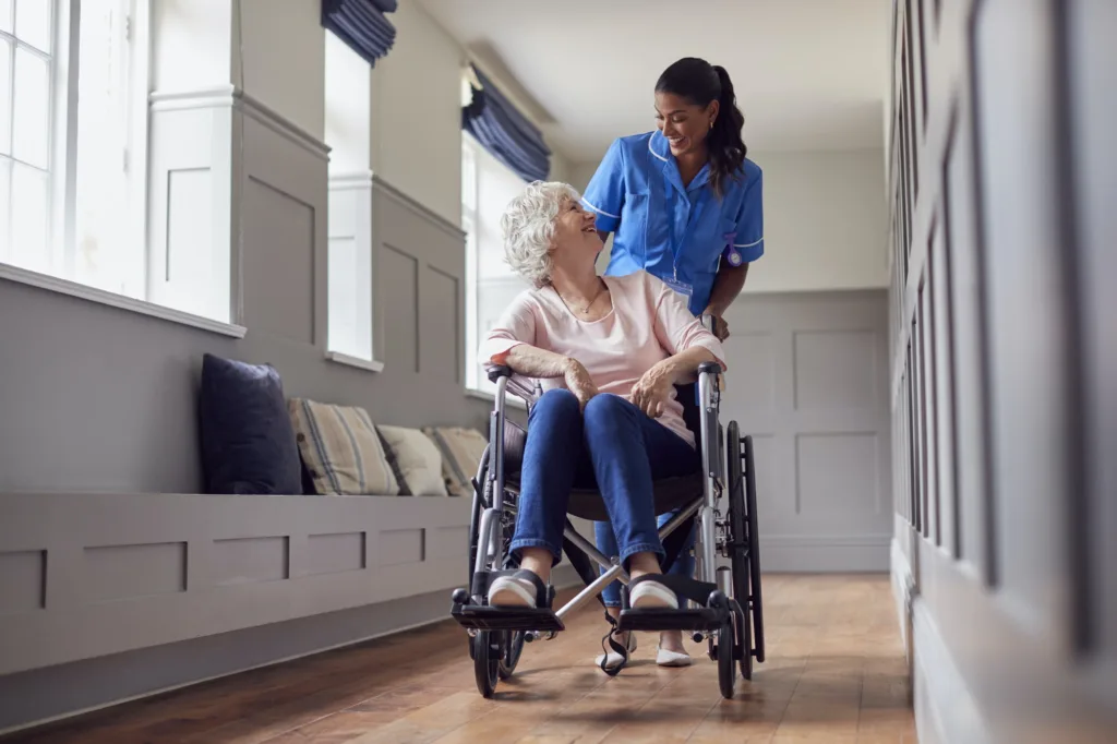 A woman in a wheelchair with another person.